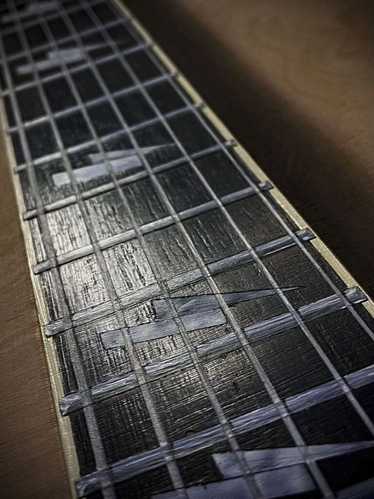 A guitar with some metal bars on it